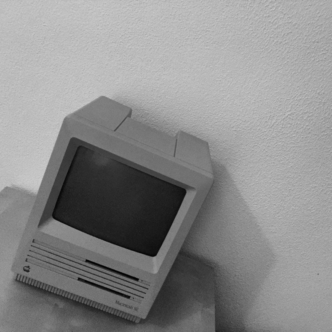 A vintage Macintosh on a table, in black and white