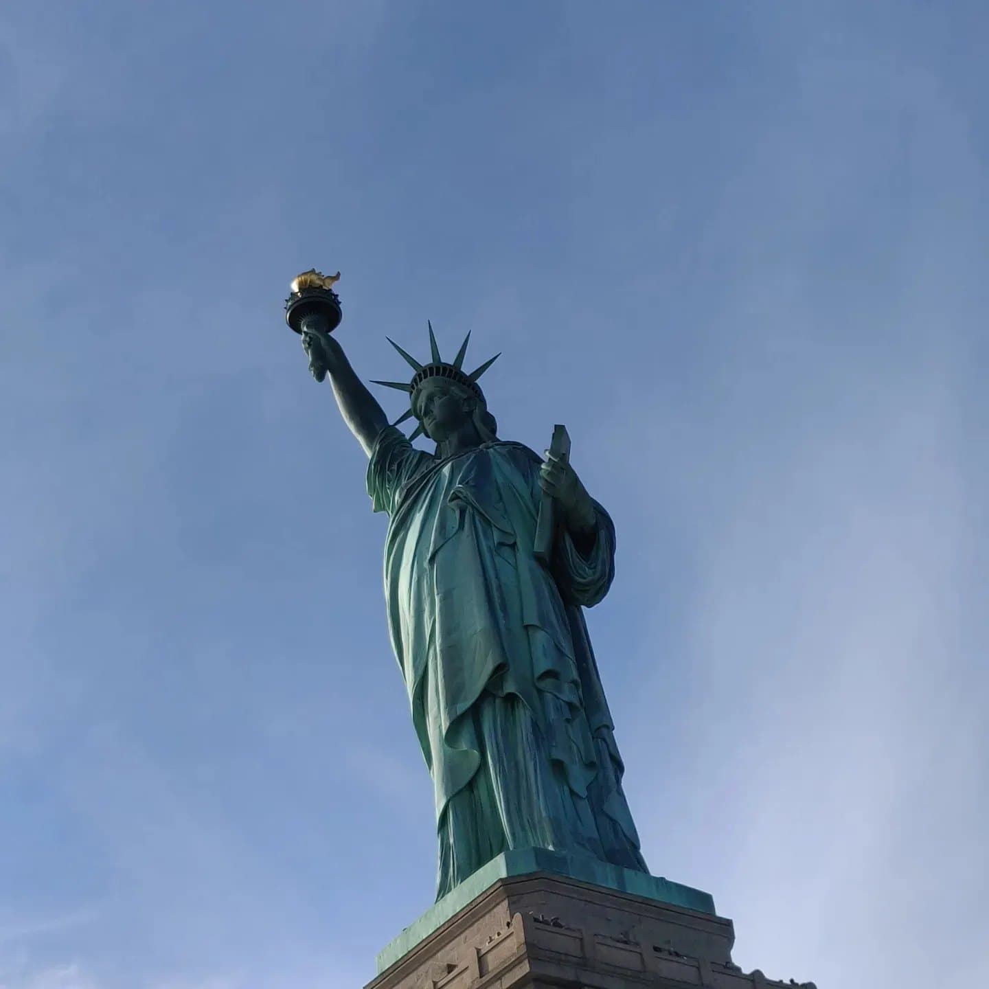 The Statue of Liberty against a pale blue sky