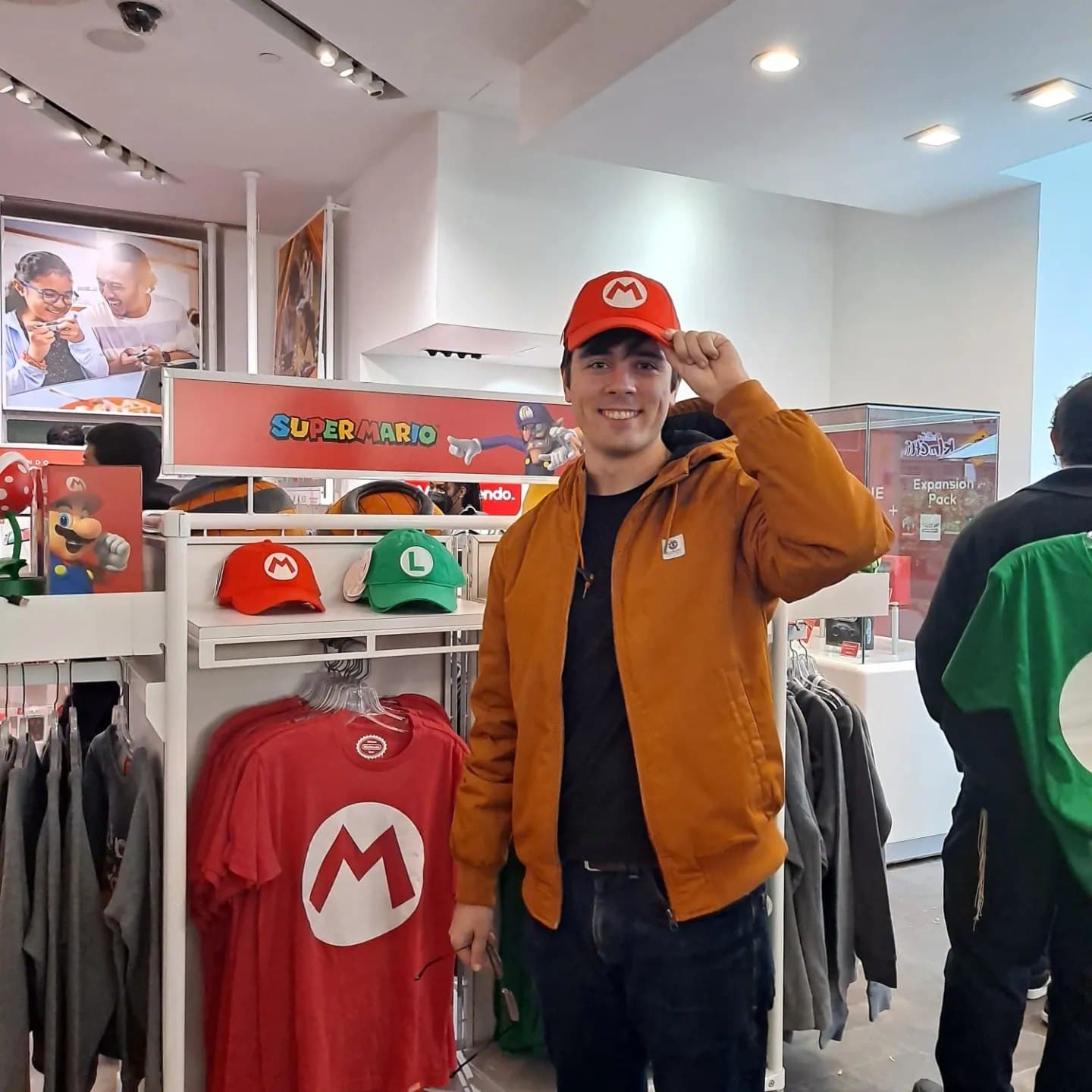 Rodrigo tipping a red Mario cap inside the Nintendo store in New York